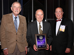 Dr. Gerald Harrrington displays his Distinguished Alumnus Award, flanked by Dr. Eugene Natkin (left) and Dr. Douglas Walsh.