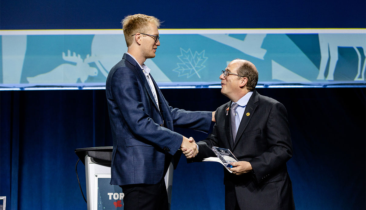 Dr. Holtzmann accepting the Research Poster Competition third place award on stage