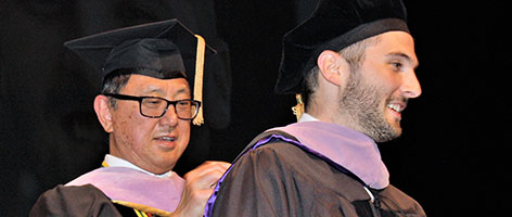Dr. Chan in graduate robes and student
