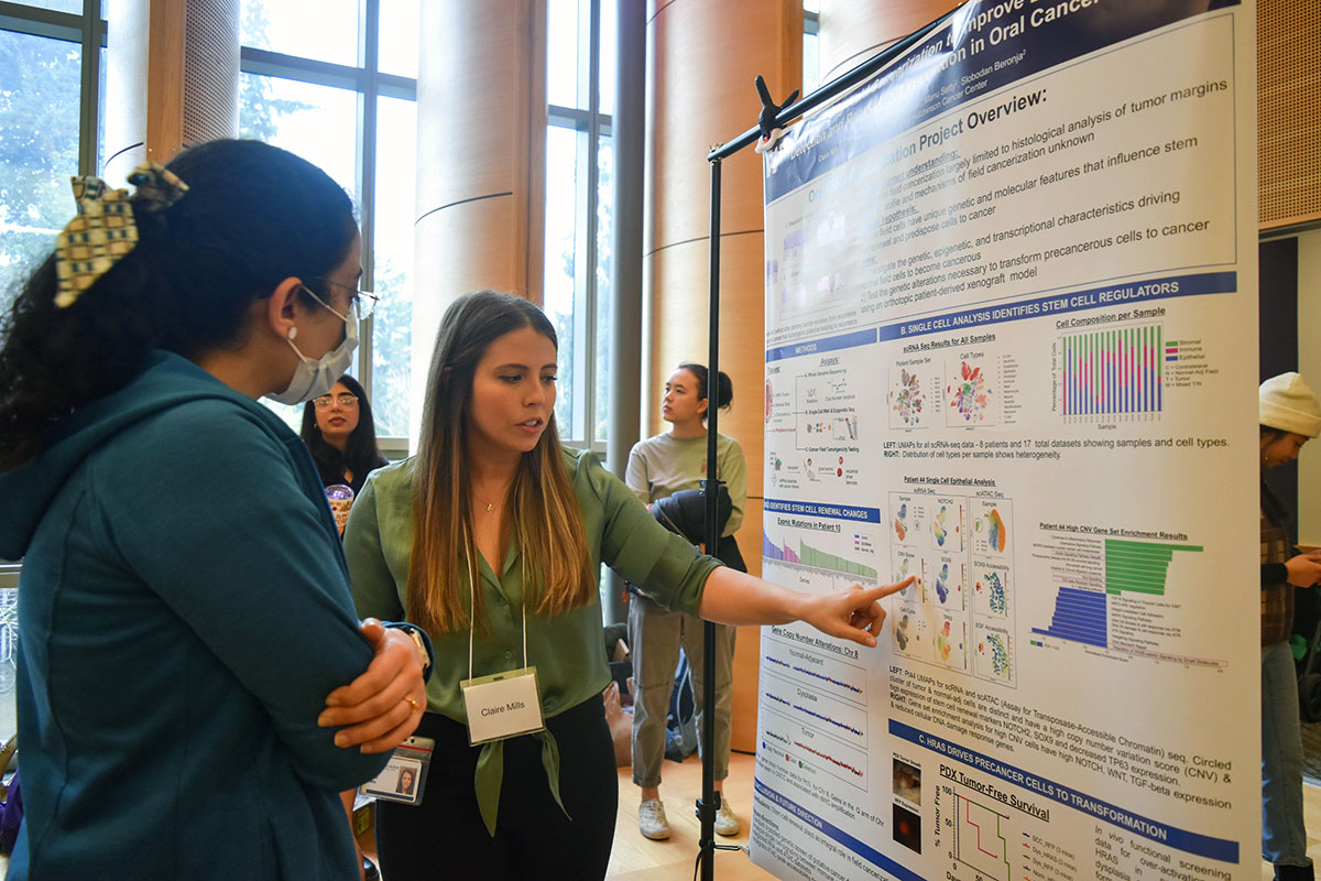 Dr. Mills presents her research project to a fellow student during the poster session.