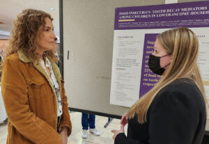 Dr. Seminario listens to a presenter at the UWSOD Research Day.
