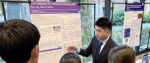 Student talking to other students about his research poster