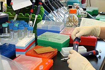 hands in laboratory with beakers and pipettes