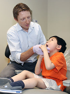 Dr. Travis Nelson treats a young patient in his autism clinic in 2013. 