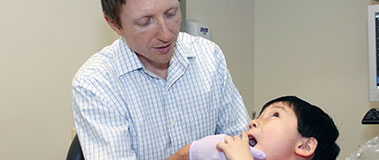Dr. Travis Nelson treats a young patient in his autism clinic in 2013. 