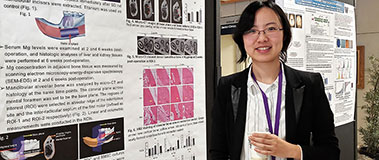 Student Wei He displays a poster presentation during the School of Dentistry’s annual Research Day on Jan. 28.