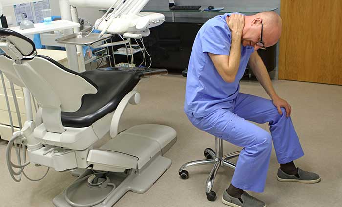 Provider in dental clinic in with neck pain