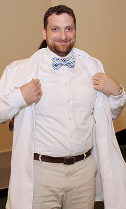 Class president Eric Olendorf puts on his new clinical coat. Class president Eric Olendorf puts on his new clinical coat.