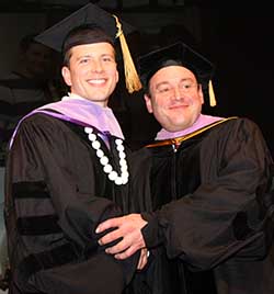 Dr. Phil Matson, Class of 2013 president, receives congratulations from Dean Berg after donning his doctoral hood.