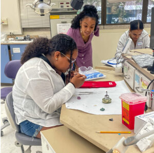 Making Connections students completing the waxing activities with Program Manager Maria Abondo looking on.